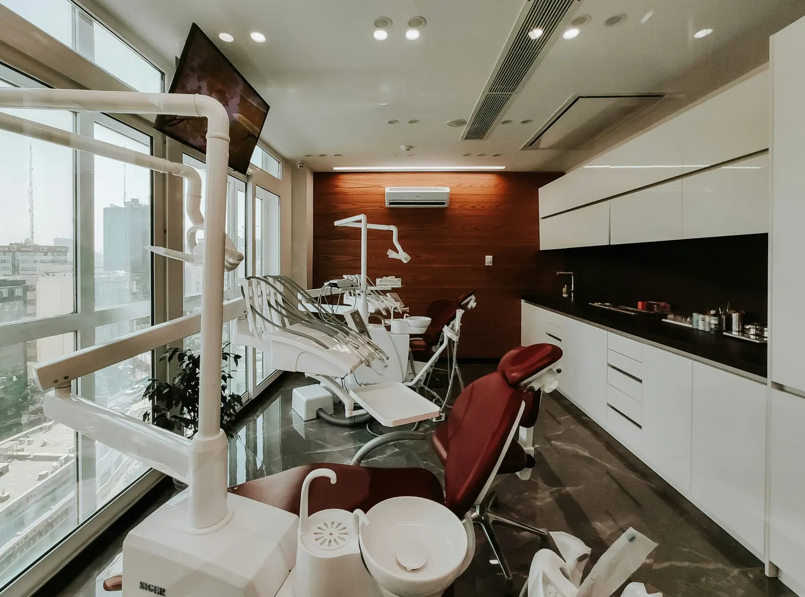 Sala de atención con ventanales, sillones odontológicos y mesada blanca